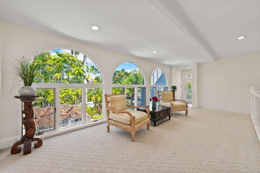 Elegant sitting room with arched windows overlooking the garden, creating a bright and tranquil space to relax.