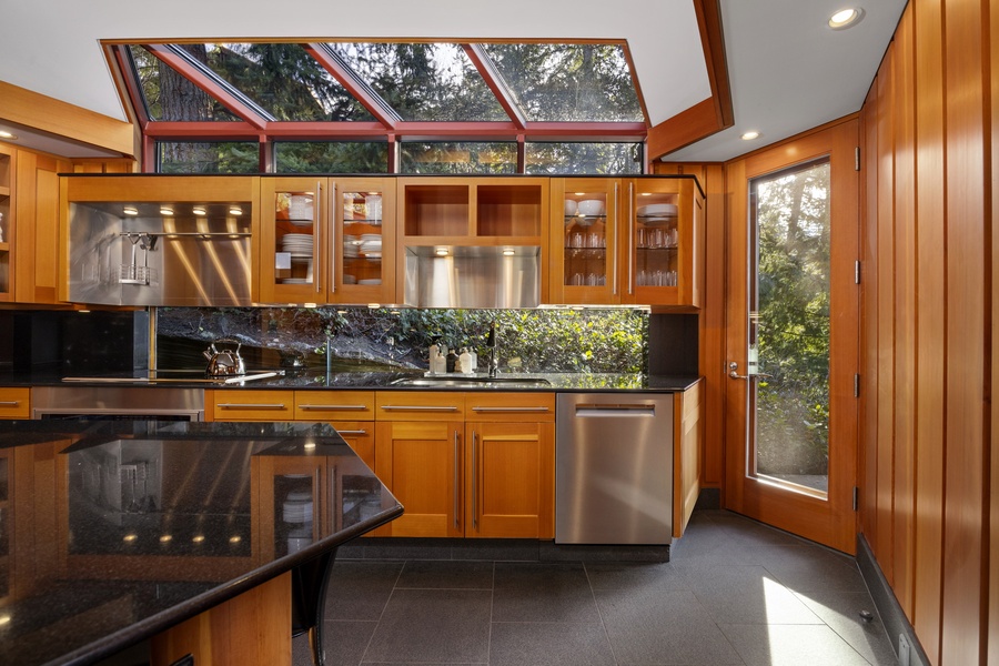 Your gourmet kitchen features warm wood cabinets, granite counters, and a dramatic skylight that fills the space with natural light.
