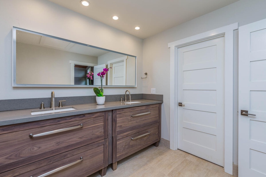 Primary ensuite has dual vanity sinks, sizable walk-in double shower, and access to private lanai.