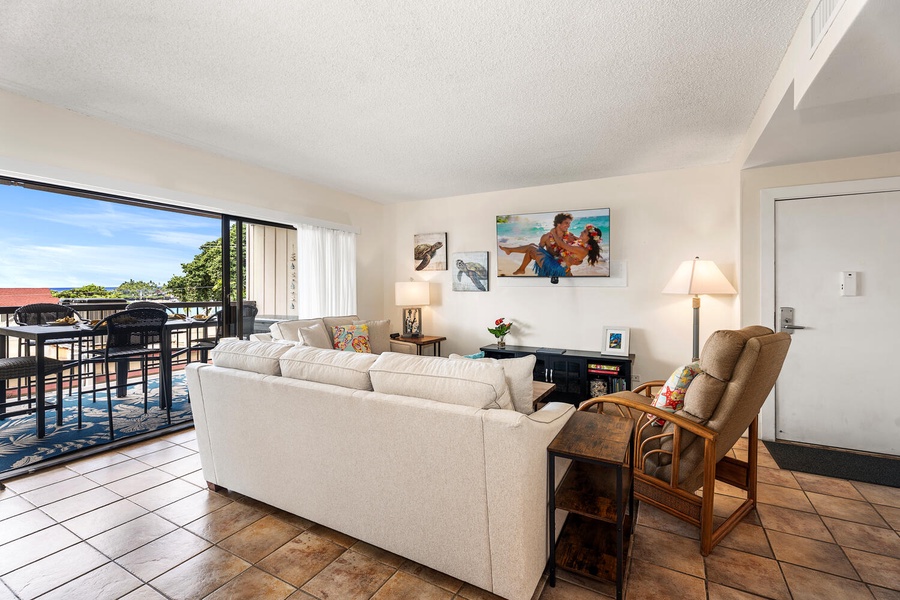 Bright living room with comfortable seating and stunning views through the large windows to outdoor spaces.