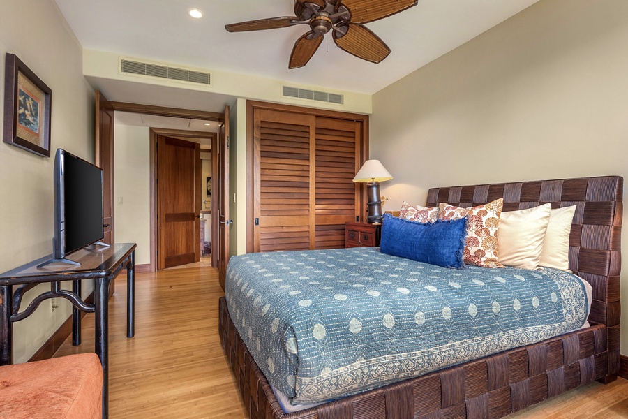 Upstairs guest room with queen bed, private balcony, flare screen TV and adjacent full bath.