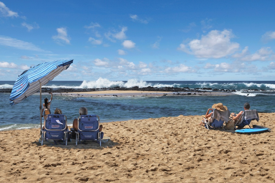 Unwind on the golden sands of Poipu Beach Park, a favorite for sunbathing and ocean breezes.