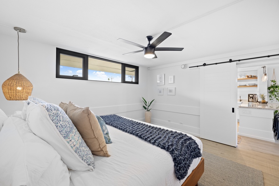 Unwind in this inviting bedroom featuring elegant linens, ample natural light, and minimalist decor for a tranquil stay.