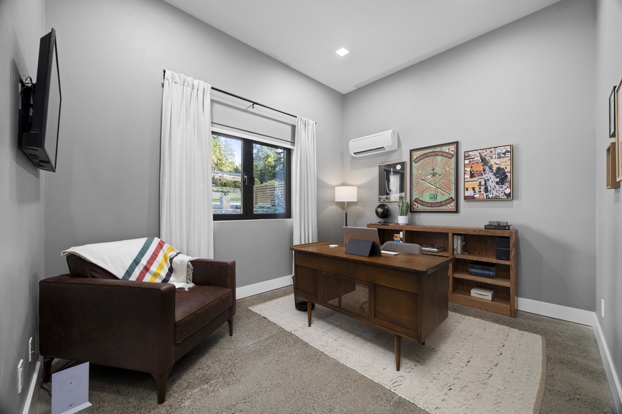 Flexible guest room or home office with natural light, workspace, and comfortable seating.