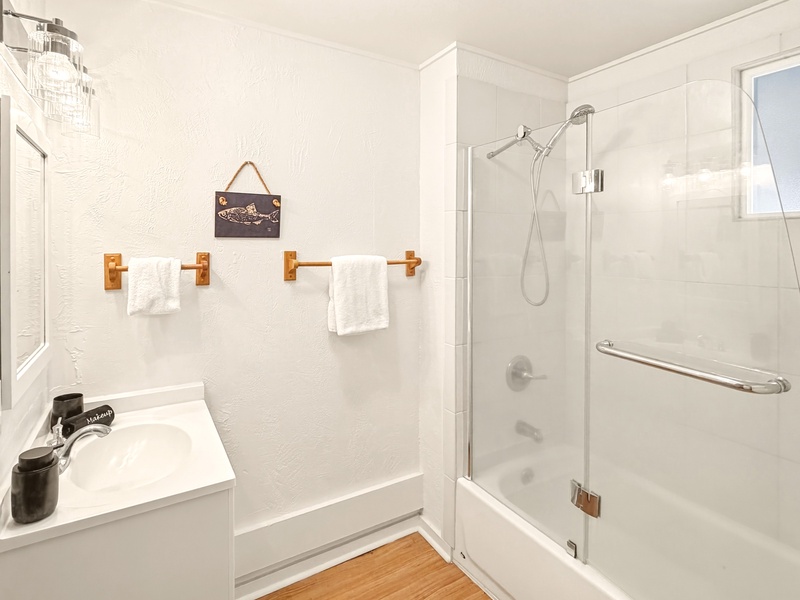 Refresh in your pristine bathroom featuring a refreshing shower, fluffy towels, and charming nautical touches that create a spa-like retreat.