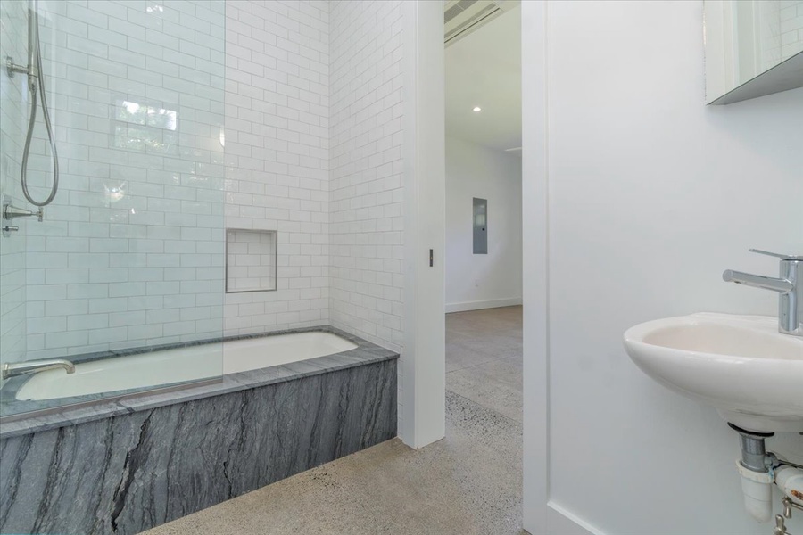 Guest bath with combination tub and shower, ideal for all ages.