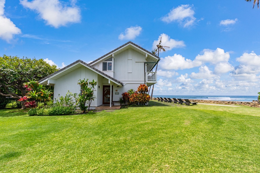 Charming beachfront property featuring tropical gardens and pristine oceanfront location with expansive lawn area.