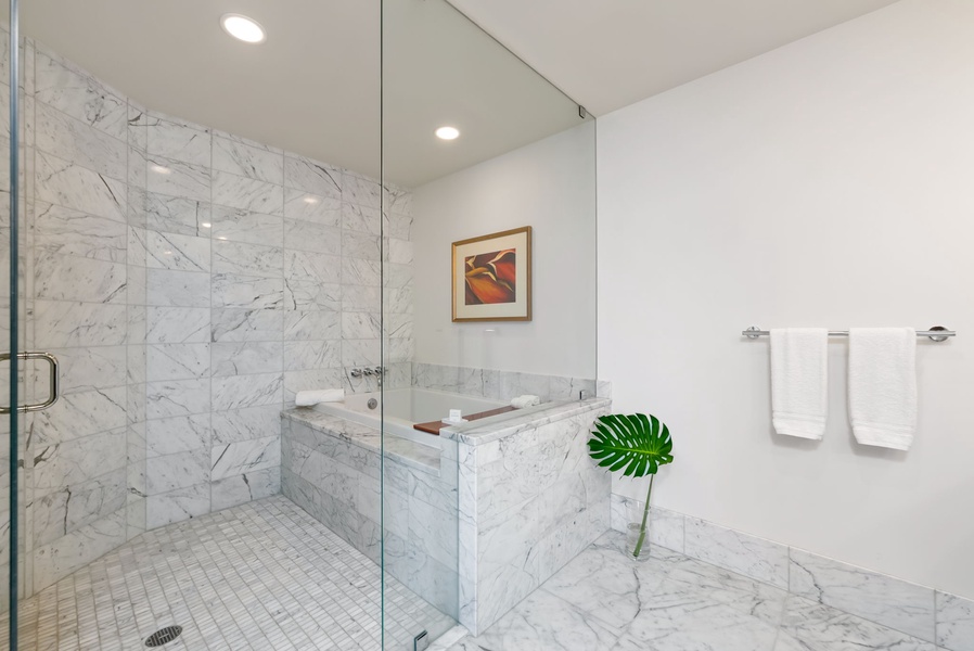 Elegant primary marble bathroom featuring a deep soaking tub for ultimate relaxation.