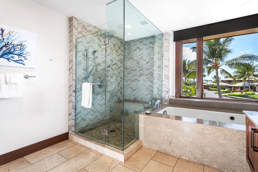 Walk-in glass shower and picture-perfect bathtub with lush surroundings.