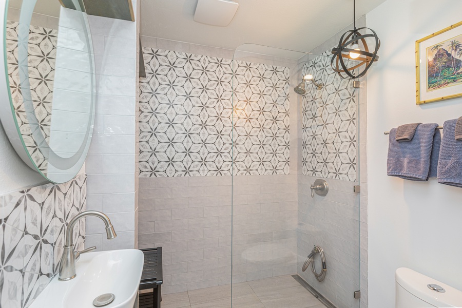 Bright downstairs bathroom with walk-in shower, custom tile, and plenty of natural light.