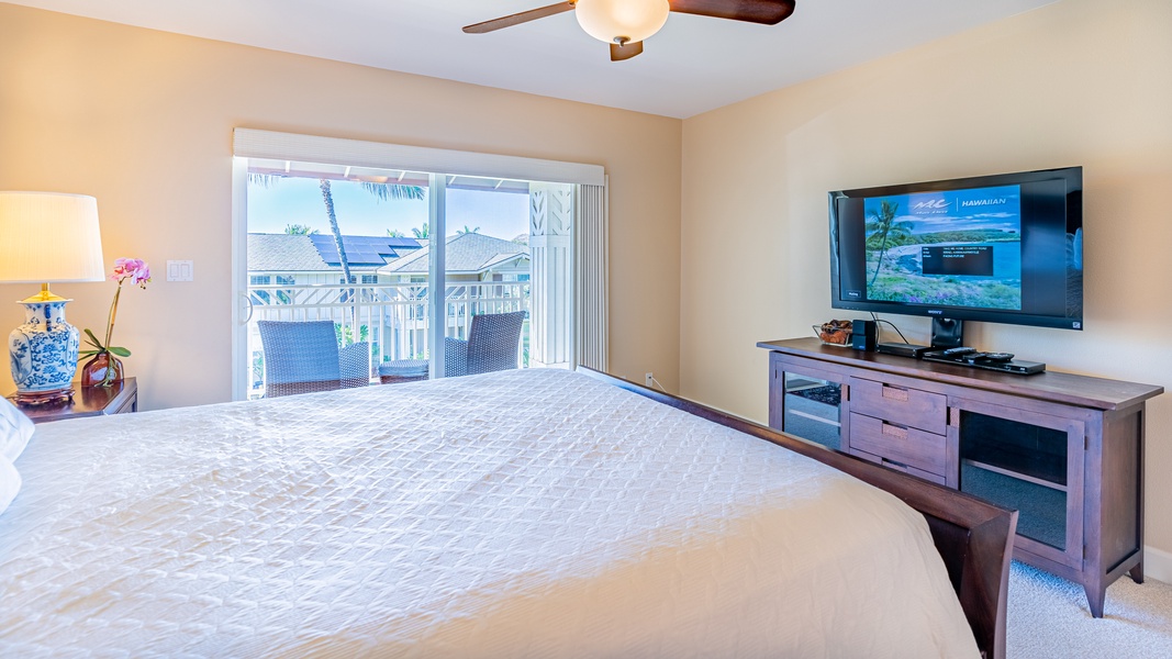 The primary bedroom with access to the lanai and a TV.