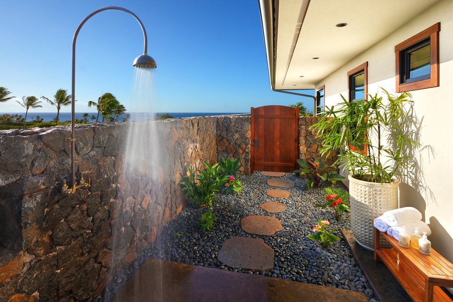 Enjoy the tranquility of an outdoor shower surrounded by tropical beauty, creating a spa-like retreat.