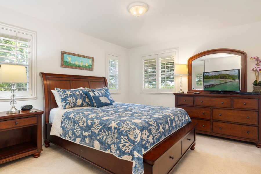 Drift off to peaceful sleep in your elegant bedroom, featuring rich wood furnishings and beautiful blue botanical linens.