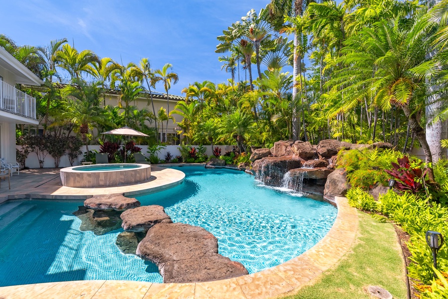 Enjoy the resort-style pool with a beautiful waterfall feature, surrounded by tropical landscaping for a serene retreat.