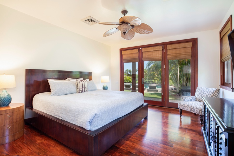 The second guest room in the main house has lanai access, a large bed, a ceiling fan, central air conditioning, and an en suite bathroom, in addition to featuring garden views.