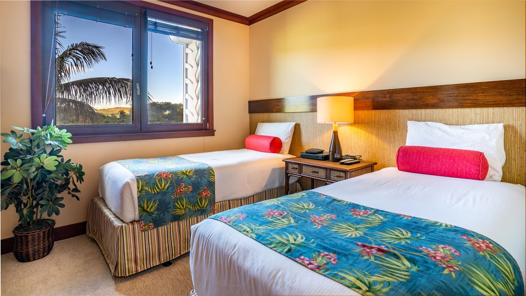 The third guest bedroom with twin beds and tropical patterns.