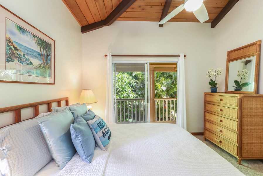 Guest bedroom with queen bed and tropical views