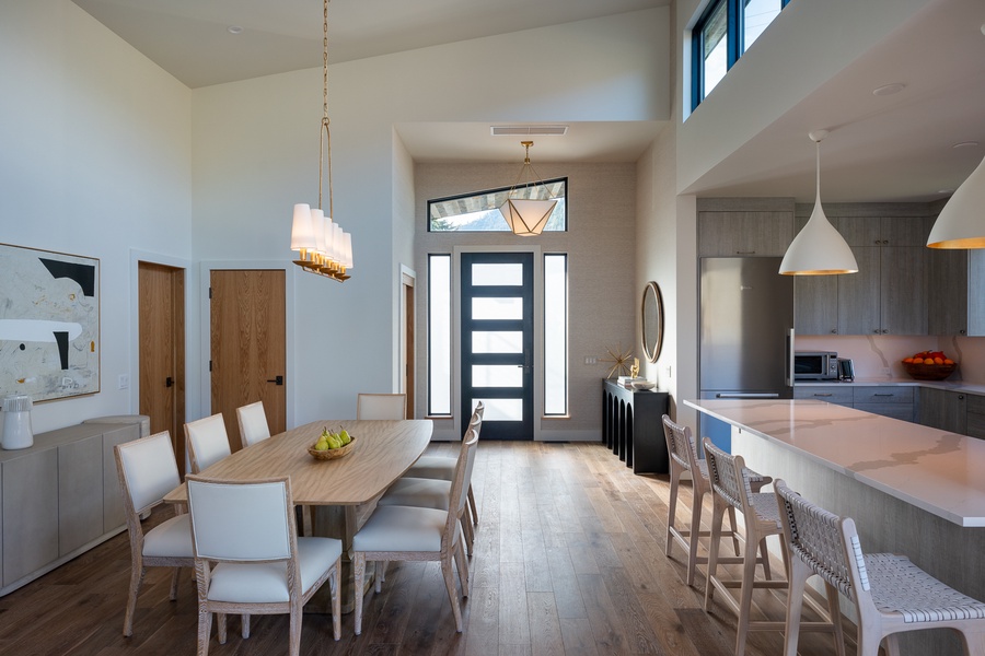 Inviting open-plan dining area seamlessly connects to the kitchen, defined by natural light and modern elegance—ideal for gatherings and gourmet experiences.