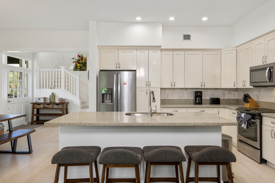 The kitchen’s spacious island and bar stools are perfect for casual meals or chatting over coffee.