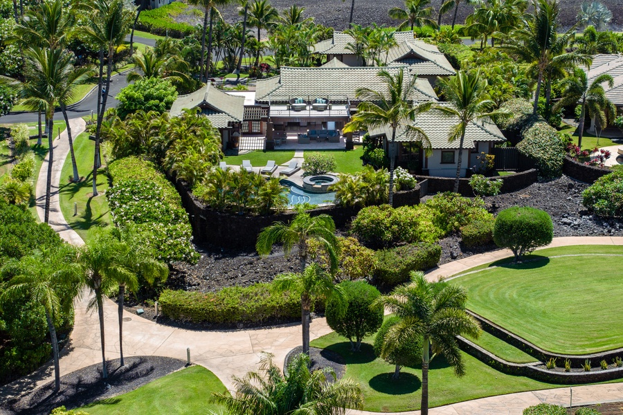 Private tropical estate with a pool, surrounded by lush greenery and a scenic landscape.