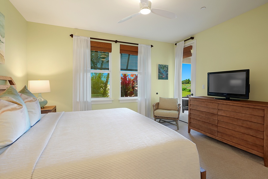 The primary suite featuring a king bed, soft natural light, and garden views.