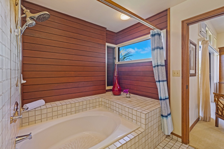 Relax and unwind in this spacious soaking tub, surrounded by warm wood paneling and a tranquil view through the window