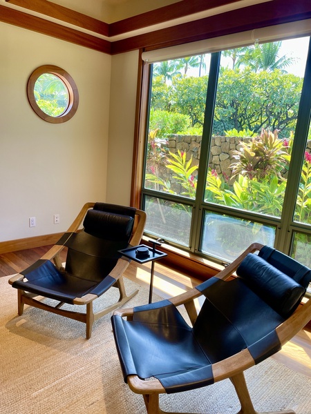 Cozy sitting nook with stylish chairs and garden views in the game area.