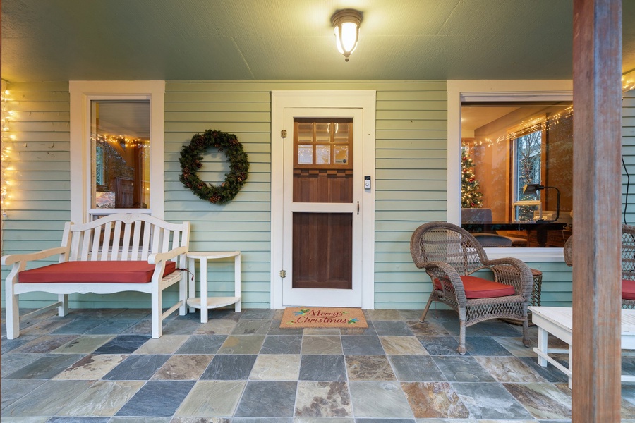 Charming front porch decorated with wreaths and holiday seating, creating a festive and inviting entry.