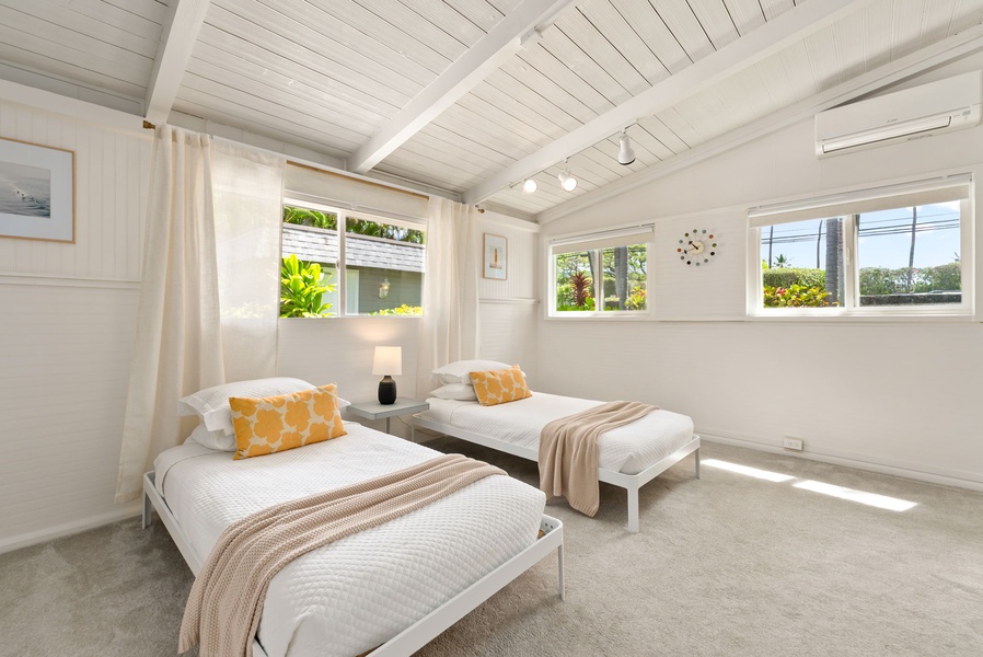 Sunlight floods your peaceful retreat, where crisp white linens, warm accents, and tropical garden views create a serene haven for restful nights.
