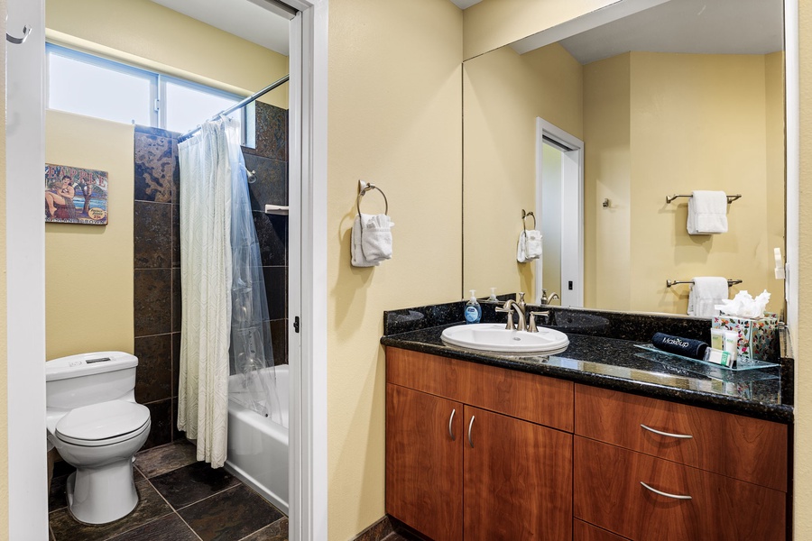 Convenient bathroom with a sleek vanity, granite countertop, and walk-in shower.