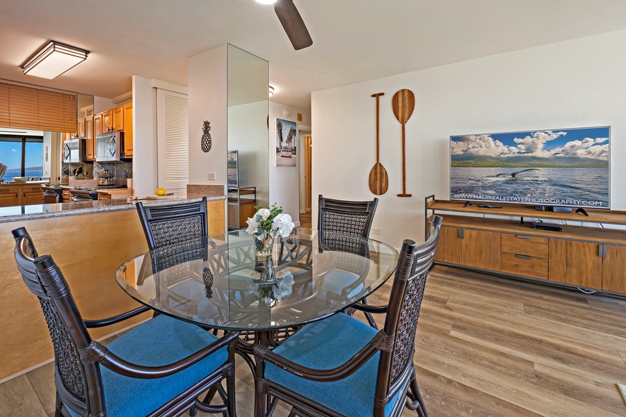 The dining area, adjacent to the open kitchen, provides a cozy spot for meals with views of the ocean, surrounded by island-inspired decor that adds a touch of tropical flair.