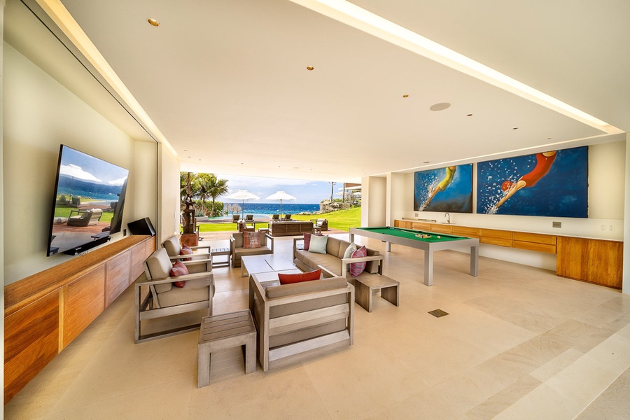 Spacious game room with comfortable seating, a pool table, and stunning ocean views.