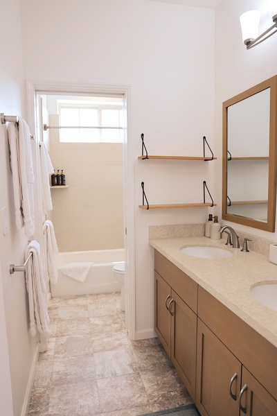 Refresh after beach days in this bright full bath with tub, shower, and plush towels.