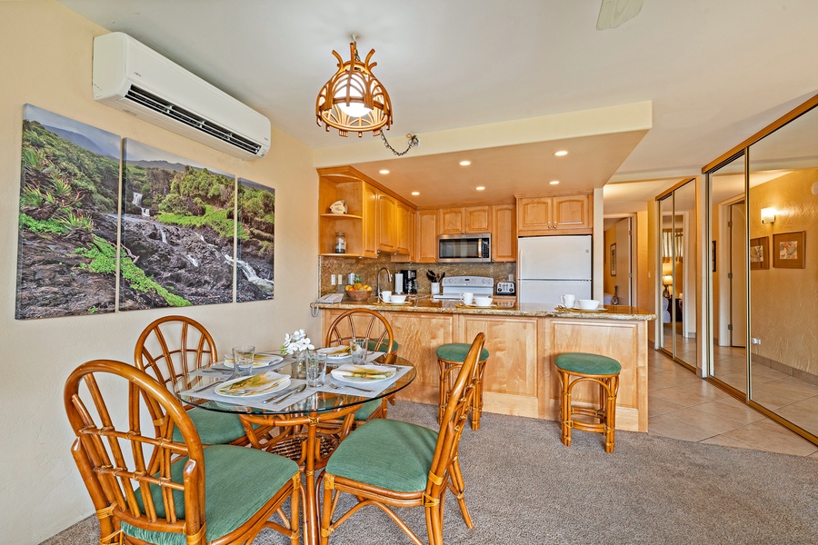 The dining area offers a comfortable spot for meals, while the nearby kitchen and breakfast bar provide additional seating options for casual dining.