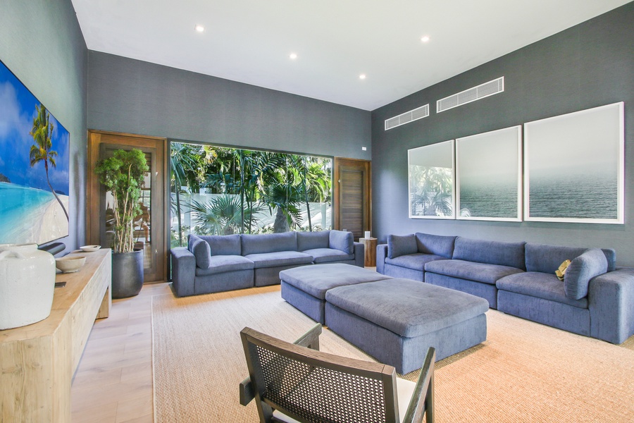 Cozy living room with plush blue sofas and a view of the garden outside.
