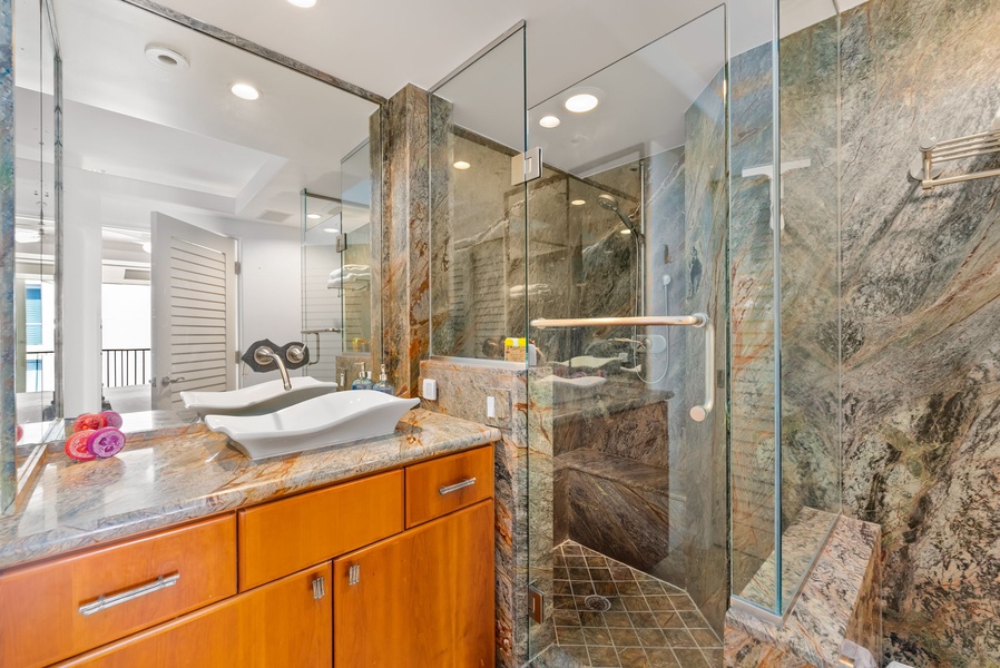 "Beautiful bathroom featuring warm wood cabinetry, granite countertops, and a glass shower for a clean and modern look.