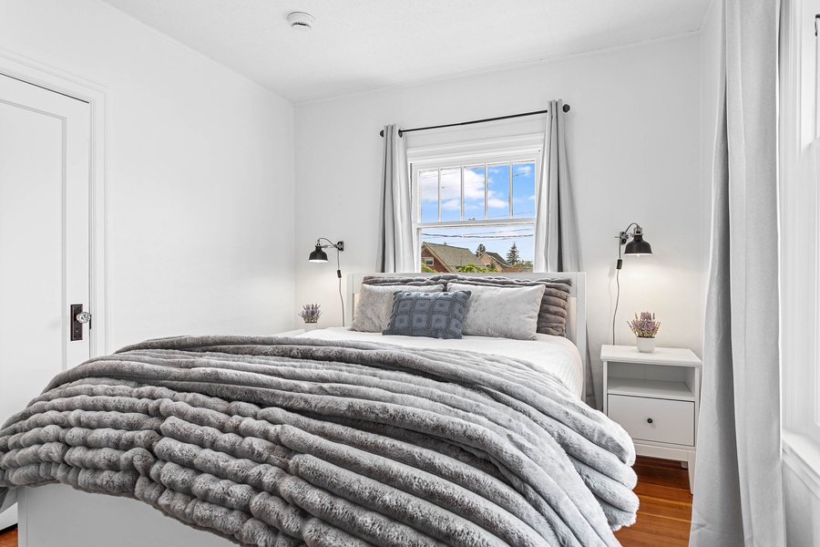 The main-level bedroom offers a queen-size bed, soft textures, and calm tones for deep rest.