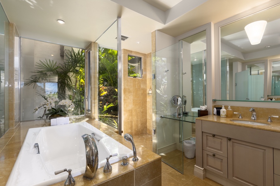 Primary en suite bath with soaking tub, shower, private W/C and tropical atrium