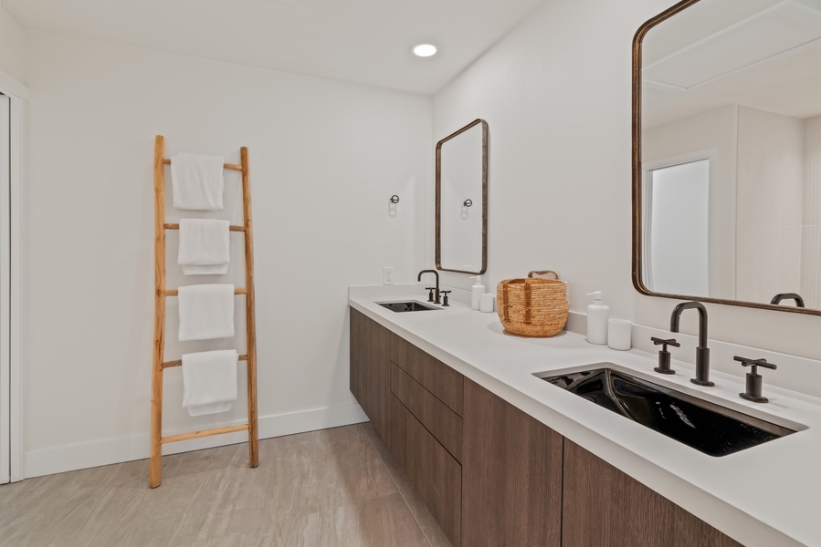 Modern ensuite bathroom with dual sinks and organic design touches.