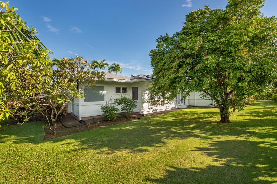 Front yard with lush greenery surrounding the home.