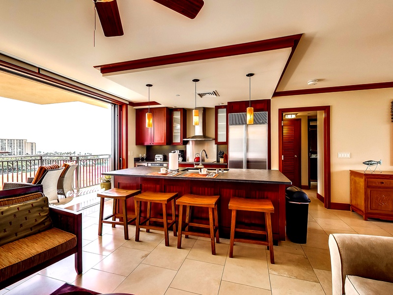 The kitchen with bar seating and stainless steel appliances.