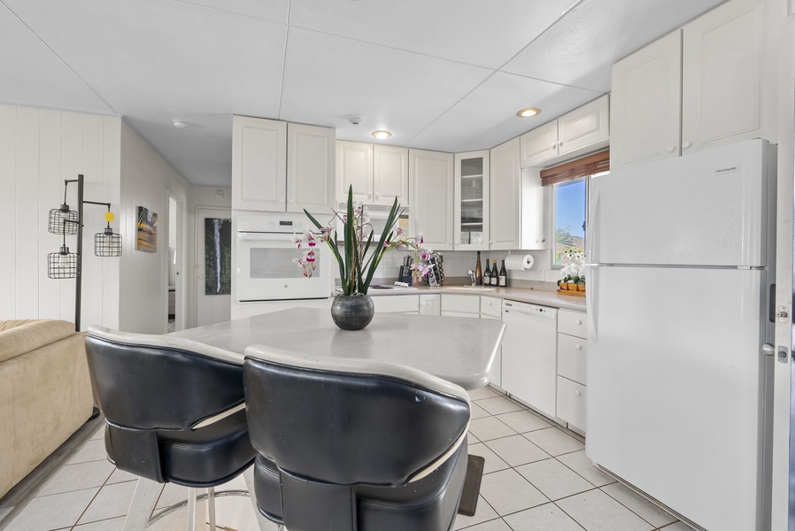 Fully equipped kitchen with full-size appliances and eat-in breakfast bar.