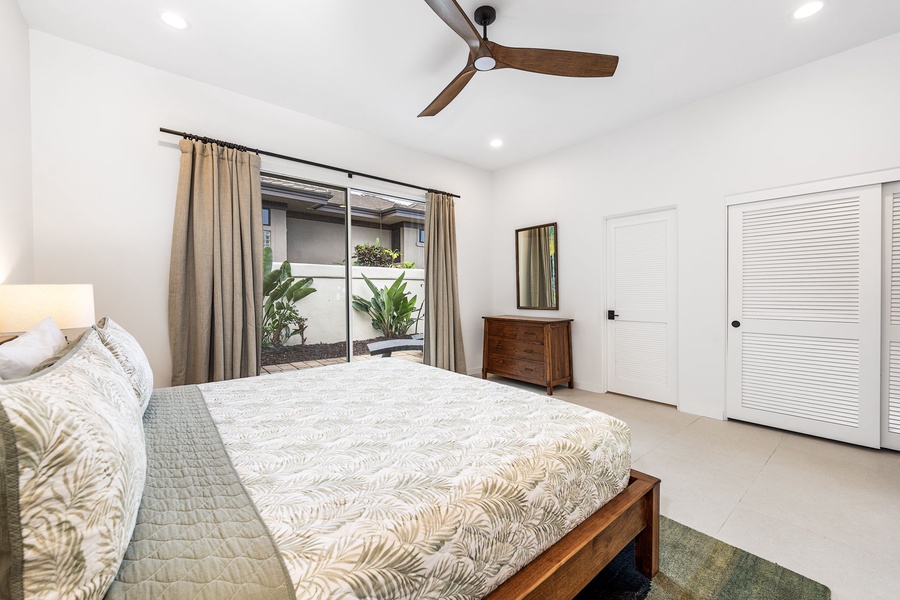 Light-filled guest room with king bed and lanai access, where mornings begin with birdsong and filtered sunshine.