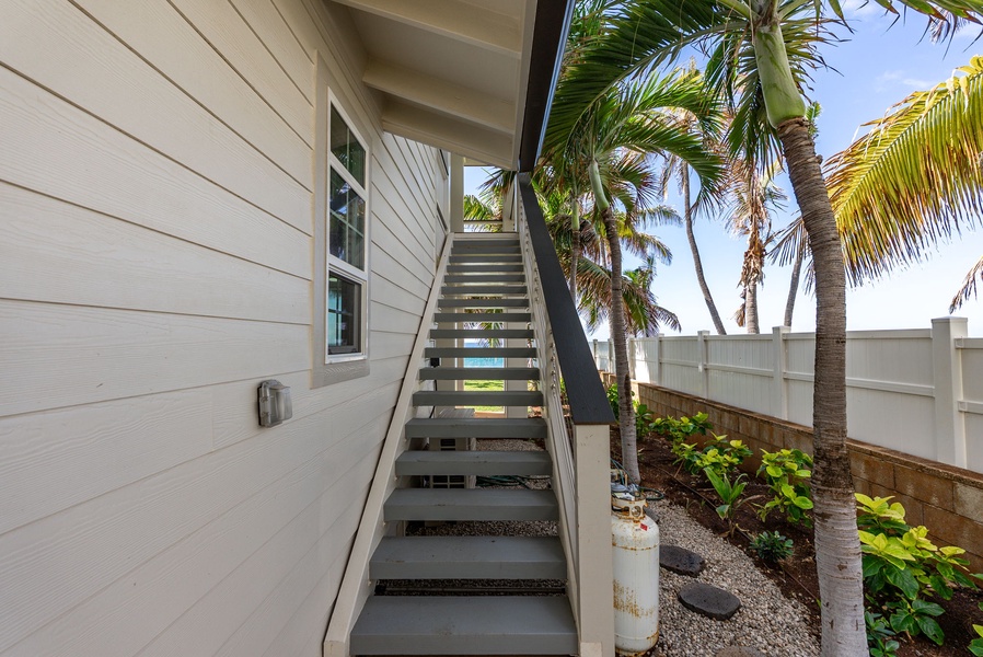 This outdoor staircase offers easy access to the upper-level suite, surrounded by lush tropical foliage and ocean breezes.