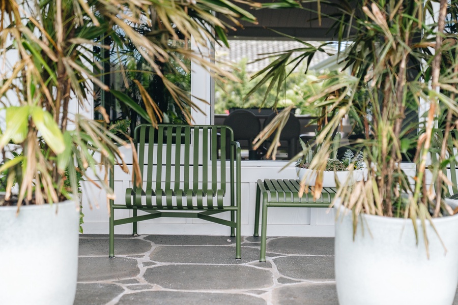 A quiet outdoor nook surrounded by lush landscaping, perfect for morning coffee or evening relaxation.