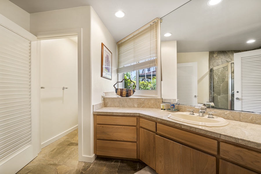 Full guest bathroom down the hall with dual vanity and bright lighting—perfect for shared use.