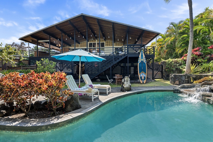 Modern tropical home with private pool, lush gardens, and outdoor entertaining spaces surrounded by palm trees and vibrant landscaping.