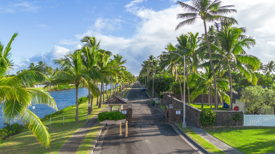 Entrance drive framed by palms leads to your private ocean‑edge retreat on the landmark peninsula.
