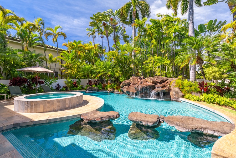 Inviting pool area with a rock waterfall and lush tropical landscaping for a serene outdoor experience.