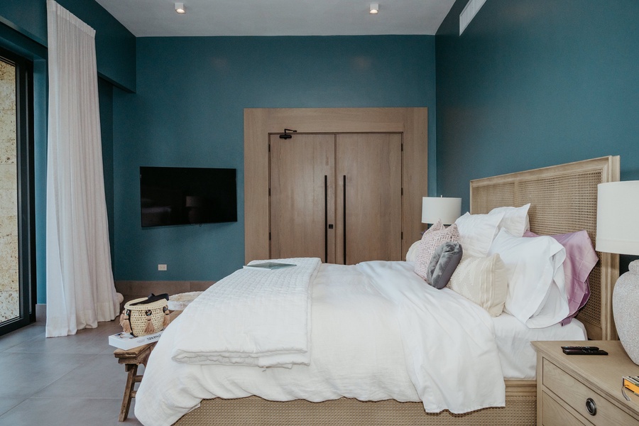 Retreat in the cozy primary suite, with a plush bed and a TV.